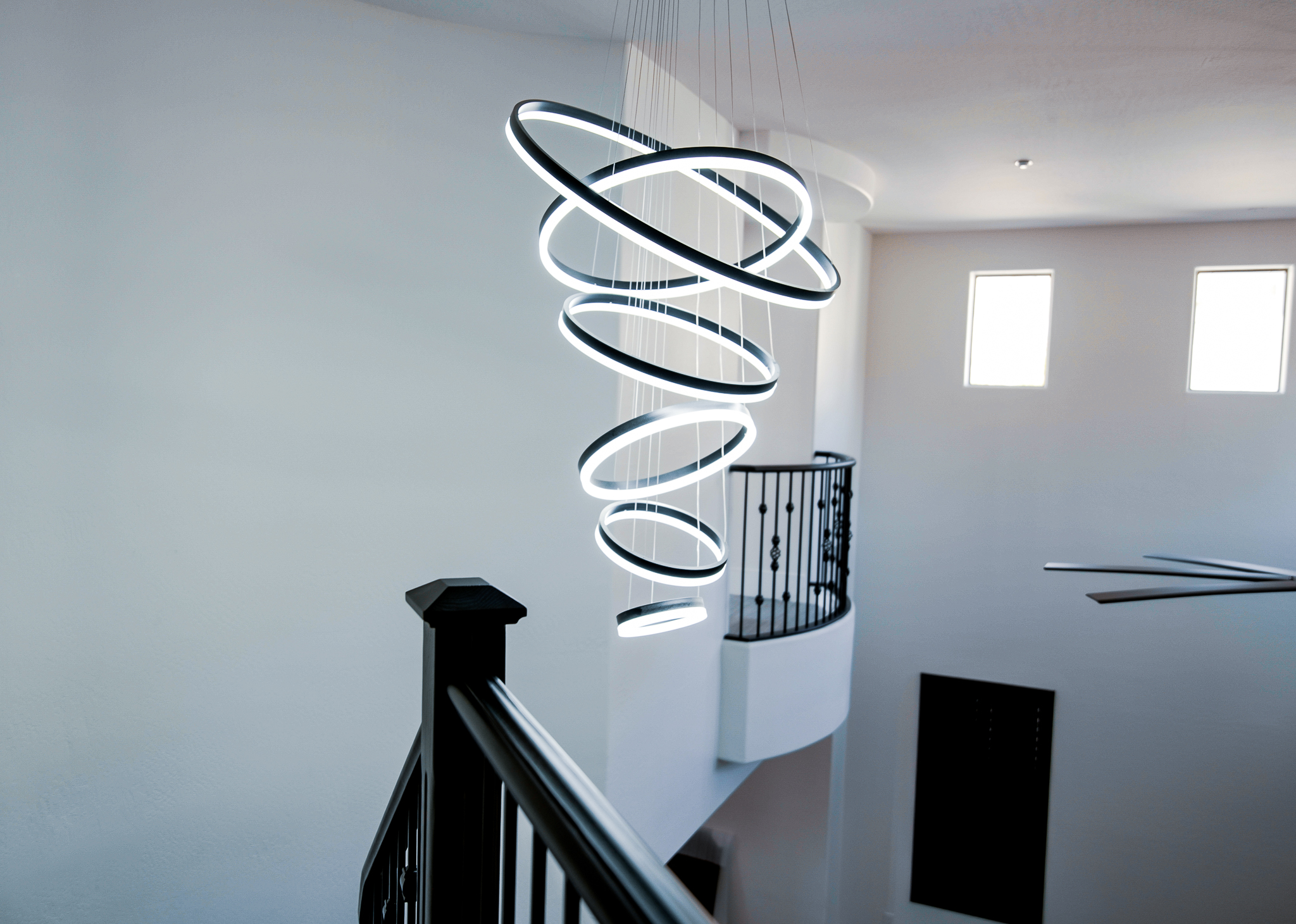 Contemporary lighting fixture with stacked LED rings in a stairwell.