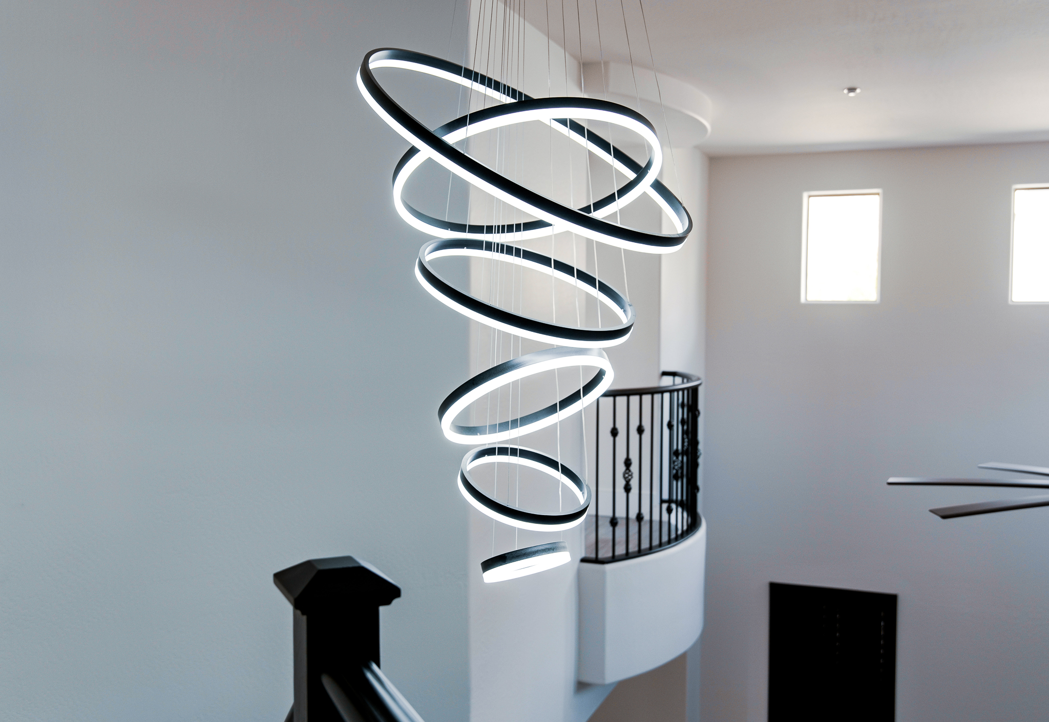 Unique spiral pendant light with eight illuminated circular rings.