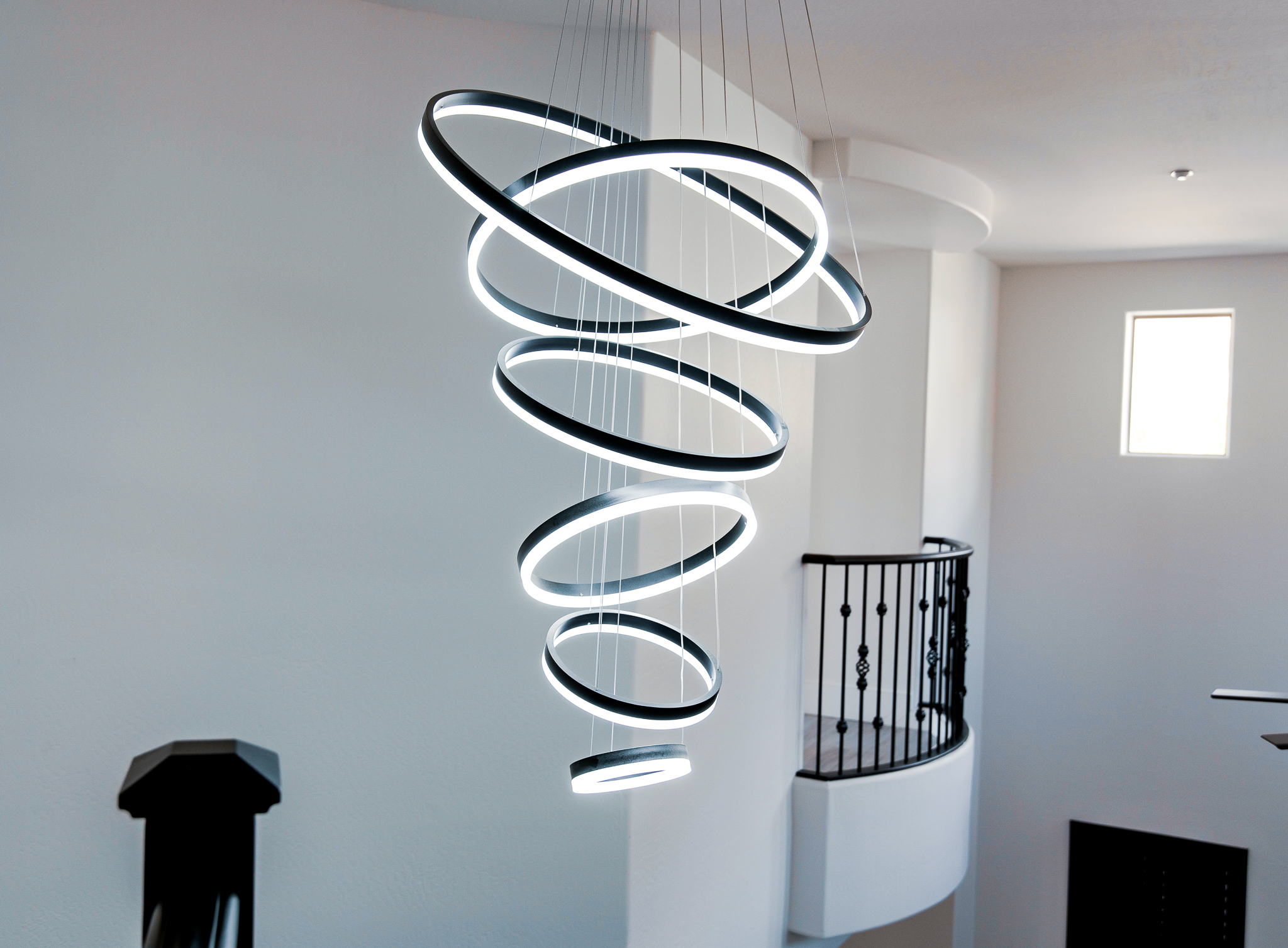 Unique spiral pendant light with eight illuminated circular rings.