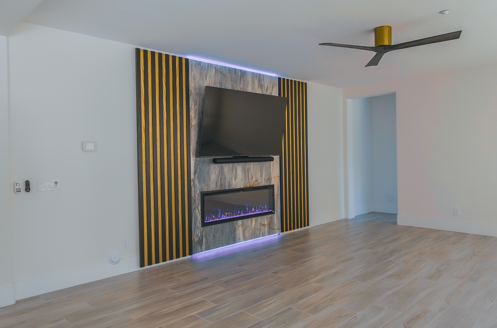 Contemporary interior featuring a flat-screen television above a linear electric fireplace.