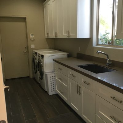 Modern laundry room Mesa with white cabinets dark floors