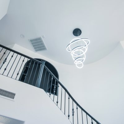 Unique spiral LED pendant light fixture with multiple illuminated rings in a contemporary home.