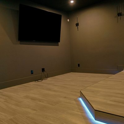 Contemporary home theater detail: a large flat-screen above a platform with blue underlighting.