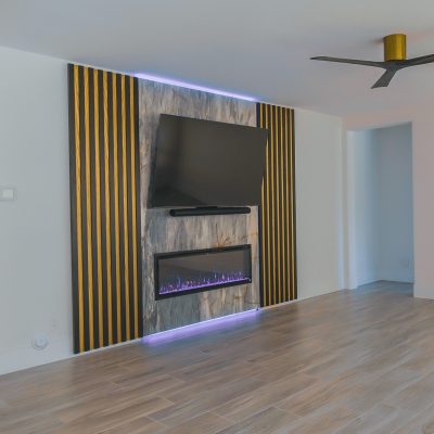 Contemporary interior featuring a flat-screen television above a linear electric fireplace.