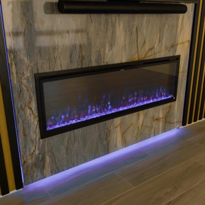 Modern black electric fireplace mounted on a marble wall with simulated flames.